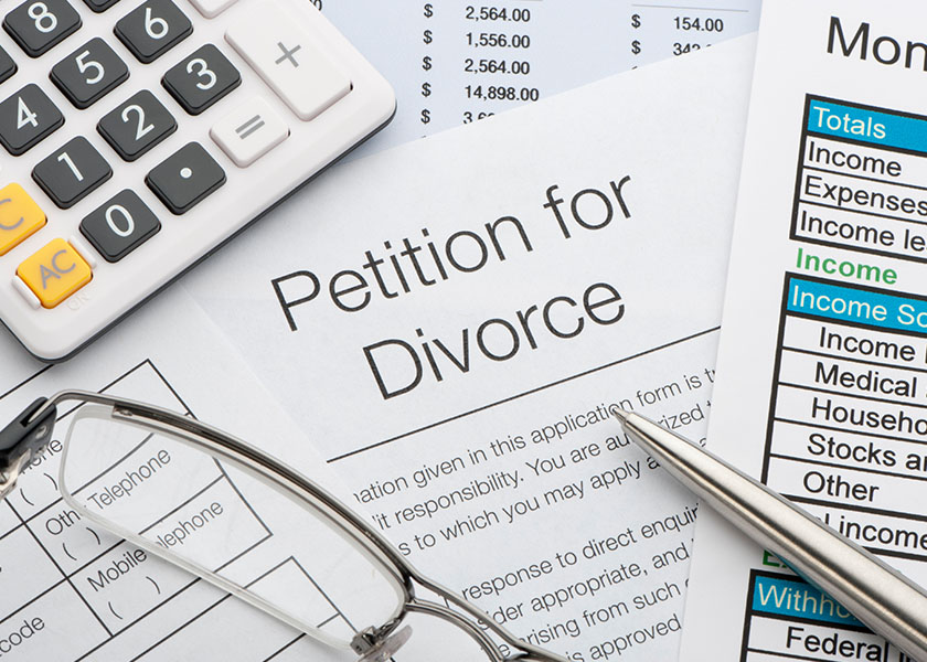 Close-up of a petition for divorce with pen and calculator